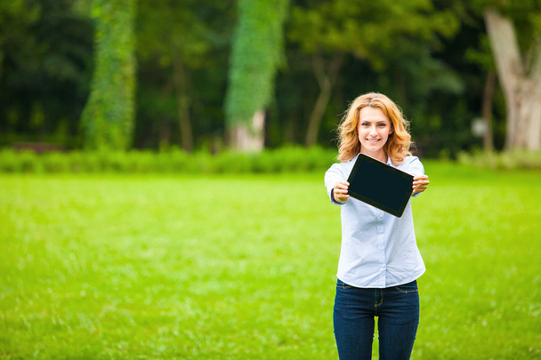 young lady with tablet in park - 写真・画像