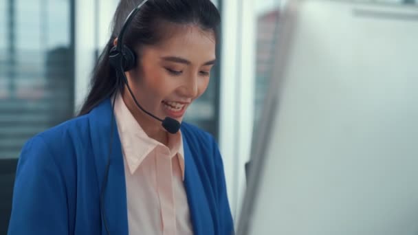 Empresaria con auriculares trabajando activamente en la oficina - Metraje, vídeo