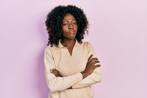 Νεαρή Αφροαμερικανή που φοράει καθημερινά ρούχα σκεπτική και νευρική, αποδοκιμάζει την έκφραση στο πρόσωπο με σταυρωμένα χέρια. αρνητικό πρόσωπο.  - Φωτογραφία, εικόνα