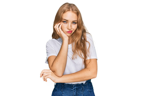 Νεαρό καυκάσιο κορίτσι φορώντας casual λευκό t πουκάμισο σκέψης κουρασμένος και βαρεθεί με προβλήματα κατάθλιψης με σταυρωμένα χέρια.  - Φωτογραφία, εικόνα