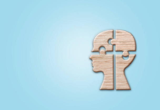 Silhouette della testa umana con un pezzo di puzzle tagliato sullo sfondo blu, simbolo di salute mentale. - Foto, immagini