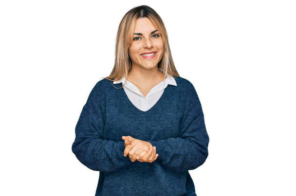 Młoda kaukaska kobieta ubrana w luźne ubrania z dłońmi i skrzyżowanymi palcami, uśmiechnięta i pogodna. sukces i optymizm  - Zdjęcie, obraz