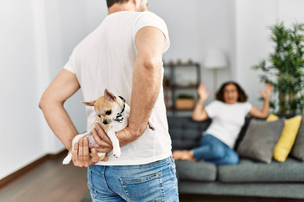 Man surprising his wife with adorable dog at home. - Photo, Image