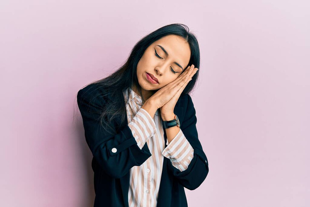 Junge hispanische Mädchen in Businesskleidung schlafen müde träumen und posieren mit den Händen zusammen, während sie mit geschlossenen Augen lächeln.  - Foto, Bild