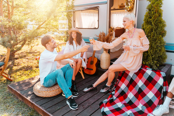 Przyjaciele urządzają piknik z kamperem na zielonej łące - Zdjęcie, obraz