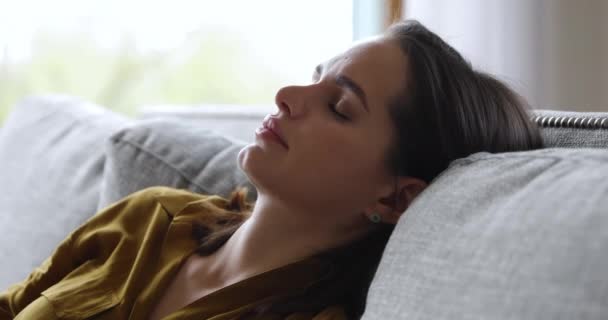 Closeup side view face of sleeping on comfy sofa woman - Materiał filmowy, wideo