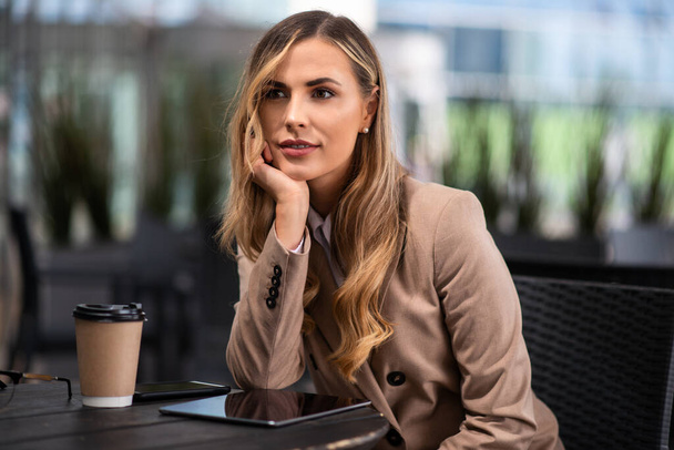Young blonde businesswoman drinking a coffee - Fotografie, Obrázek