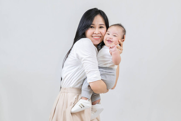 happy family, Young asian mother, hugging her newborn baby smiling, holding him in her arms and smiling from happiness - Foto, immagini