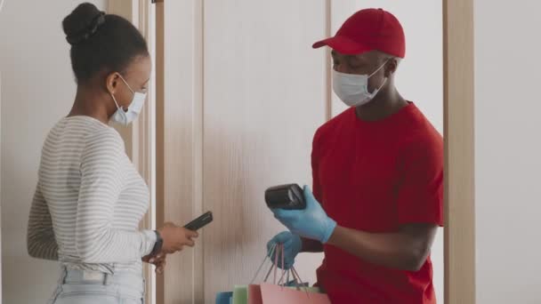 Servicio seguro de compras y entrega en línea. Mujer afroamericana joven que paga por el pedido de ropa con aplicación para teléfonos inteligentes - Metraje, vídeo