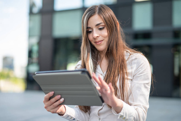 Smiling businesswoman using a tablet outdoor near her office - Foto, immagini