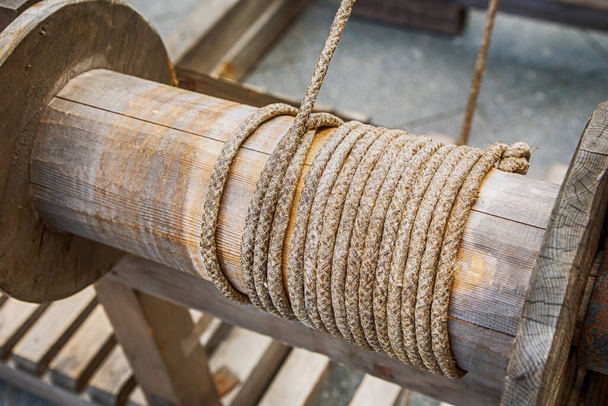 Hebemechanismus des Wassers aus einem Brunnen mit einem dicken Seil gewickelt mit einem Seil - Foto, Bild