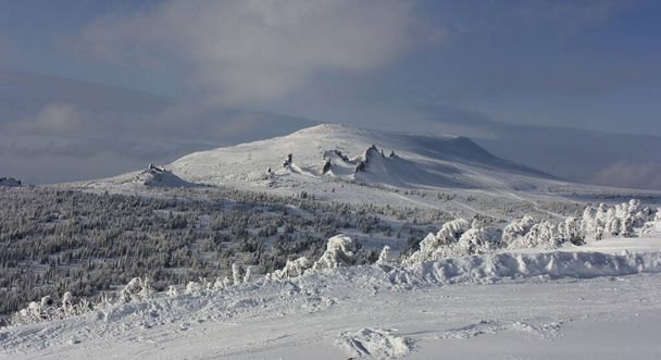 hófödte hegyek pöttyös szerpentin nyomokban snowboardosok és síelők - Fotó, kép
