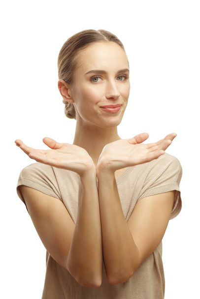 Portrait of young smiling woman holding hands up with open palms pretends holding something isolated over white background - Foto, afbeelding