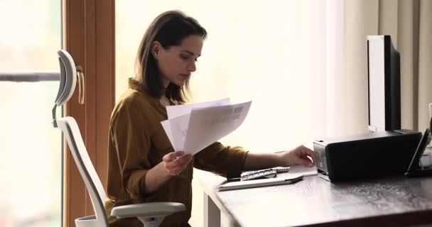 Serious businesswoman do paperwork seated at workplace desk - Séquence, vidéo