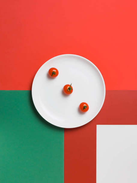 three red cherry tomatoes on a white plate - Zdjęcie, obraz