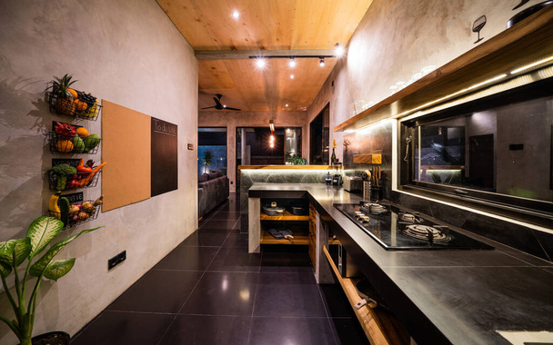 Moderne große Luxus dunkelgraue Küche Nahaufnahme mit Weinflasche am Küchentisch, leise - Foto, Bild