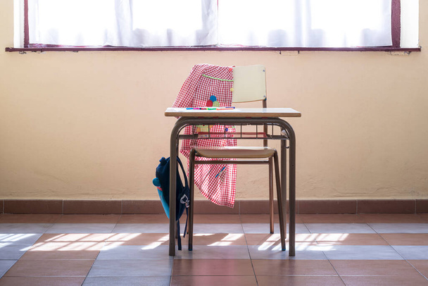 Photograph of a desk and chair in a primary classroom where you can see the typical material of a child student.The photo is taken in horizontal format. - Photo, Image