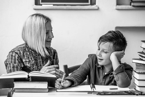 Basisschool student tijdens huiswerk met een mentor. Zwart-wit foto. - Foto, afbeelding