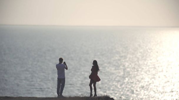Το ρομαντικό ζευγάρι που φωτογραφίζεται στην ακτή της θάλασσας - Φωτογραφία, εικόνα