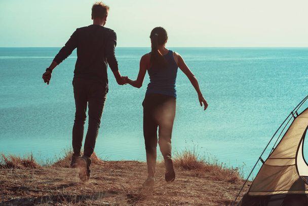 Мужчина и женщина веселятся в кемпинге у моря - Фото, изображение