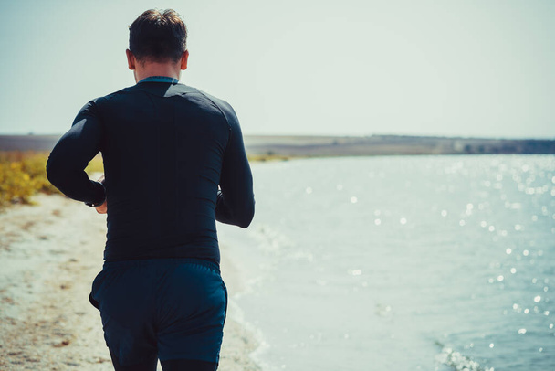 Der Mann joggt an der Küste entlang - Foto, Bild