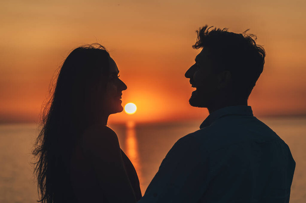 Kaksi onnellista ihmistä seisomassa kauniilla auringonlaskun taustalla - Valokuva, kuva