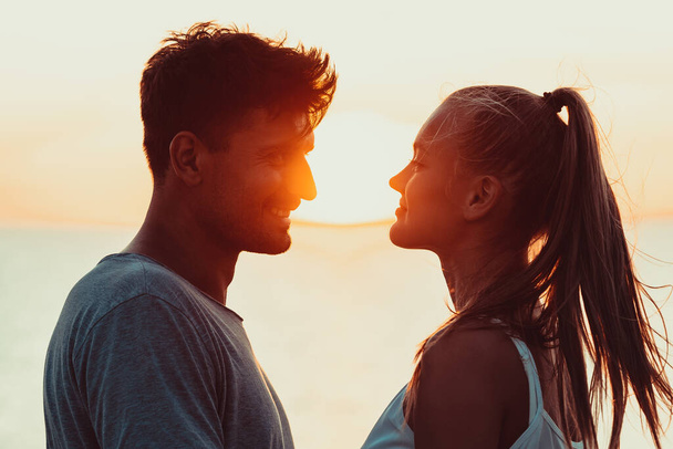 Romanttinen pari seisoo tiiviisti kauniilla auringonlaskun taustalla - Valokuva, kuva