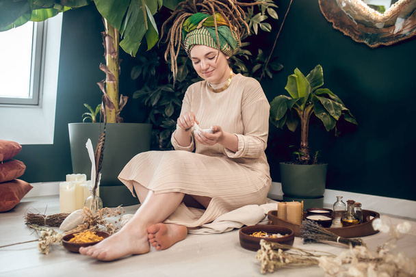 Smiling woman with high hairdo making herbal blend - Fotografie, Obrázek