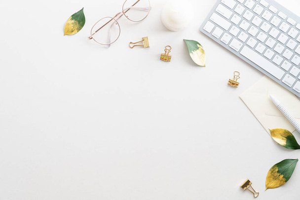 Feminine workspace with keyboard, glasses, fall leaves on white background. Home office desk table top view. Flat lay. - Foto, Imagem