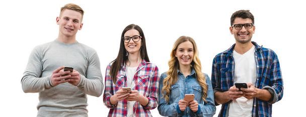 The four happy people with phones stand on the white wall background - Valokuva, kuva