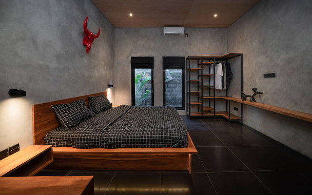 Dormitorio oscuro de lujo con cama de madera moderna en estilo loft habitación de diseño de interiores - Foto, Imagen