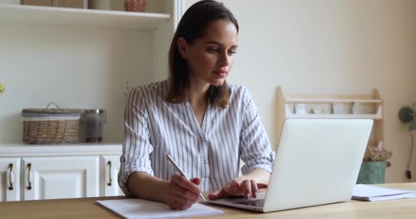 Увлеченная женщина работает или учится, ищет полезную информацию в Интернете - Кадры, видео