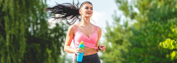ボトルの屋外を走るスポーツ女性 - 写真・画像