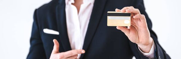 Ο επιχειρηματίας με μια πιστωτική κάρτα στέκεται στο λευκό φόντο - Φωτογραφία, εικόνα