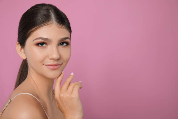 Portrait of pretty girl on pink background, space for text. Beautiful face with perfect smooth skin - Zdjęcie, obraz