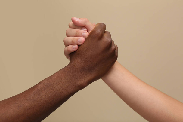 Men clasping hands on beige background, closeup - Foto, immagini