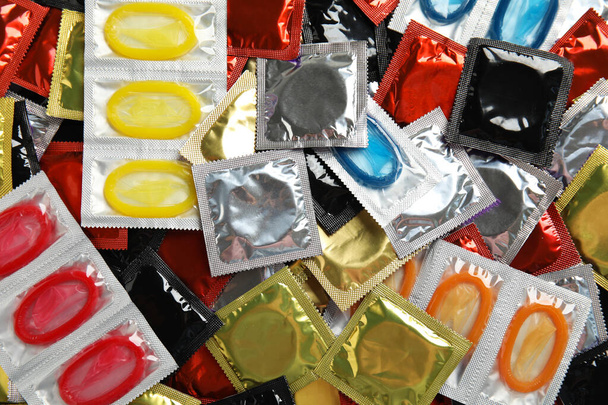 Pile of different condoms as background, top view - Fotoğraf, Görsel