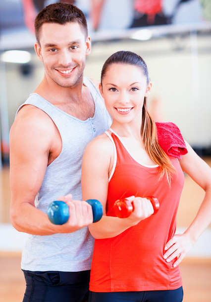 two smiling people working out with dumbbells - Fotoğraf, Görsel