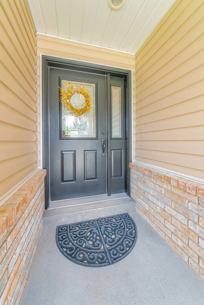 Eingang eines Hauses mit schwarzer Holztür und Fußmatte - Foto, Bild