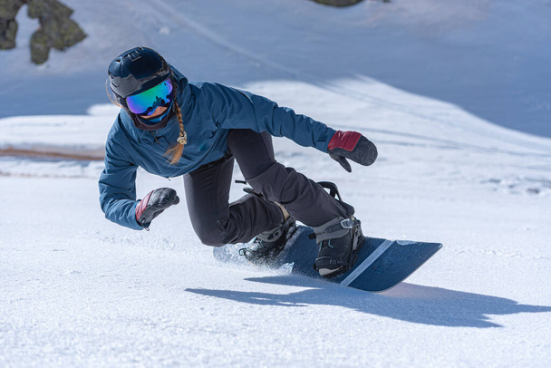 Mujer joven snowboarder en movimiento en snowboard en las montañas. - Foto, imagen