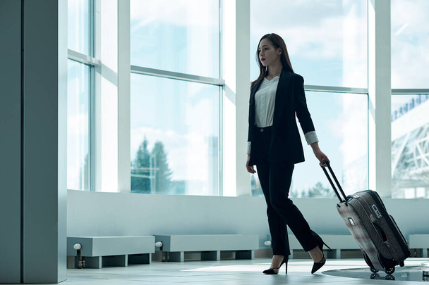 Young asian business woman at the airport with trolley bag, waiting for departure. - Photo, Image