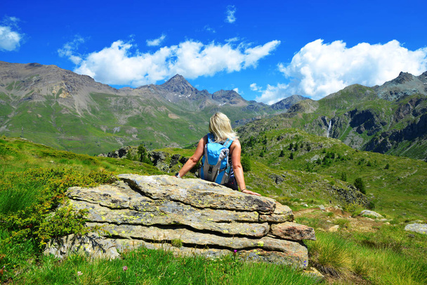 Hiker in the Gran Paradiso National Park. Aosta Valley, Italy. Beautiful mountain landscape in sunny day. - Φωτογραφία, εικόνα