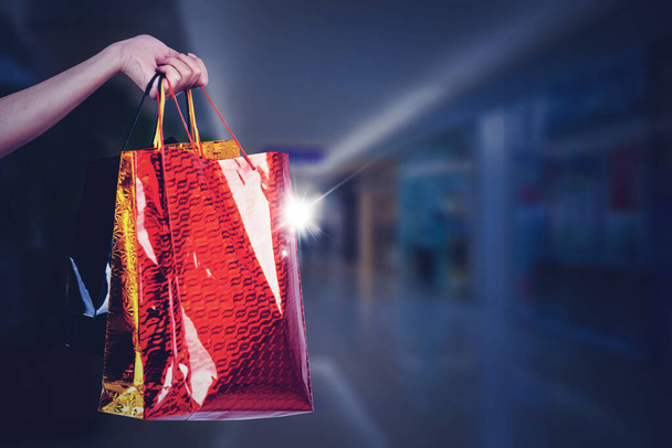 Close up of woman hand holding shopping bags while standing in the mall - Foto, imagen