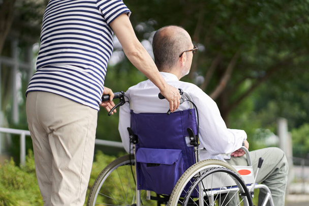 Famiglia che sostiene gli anziani in sedia a rotelle - Foto, immagini