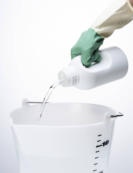 Pour the detergent into the bucket - Photo, image