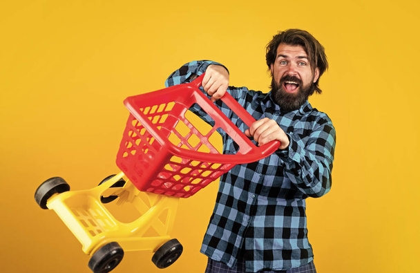 brutal bearded male with stylish look carry shopping trolley, cyber monday - Fotografie, Obrázek