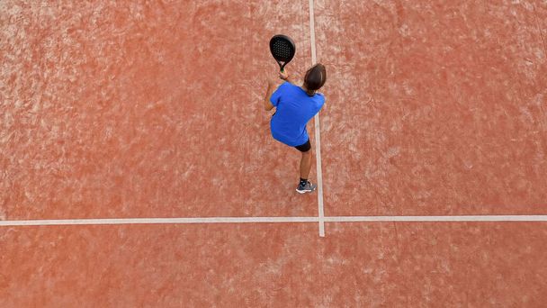 Açık hava maçında topa vuracak profesyonel bir raket tenisçisinin üst görüntüsü. - Fotoğraf, Görsel