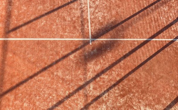 Textur eines Outdoor-Paddle-Tennisplatzes von oben gesehen. Orangefarbener Hof mit weißen Linien. - Foto, Bild