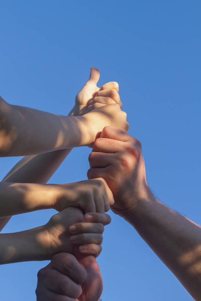 The team of players put their hands together as a sign of unity and support. - Foto, afbeelding