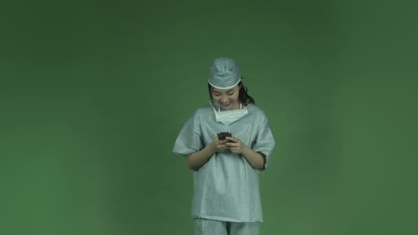 Mujer asiática médico cirujano sms teléfono celular
 - Imágenes, Vídeo